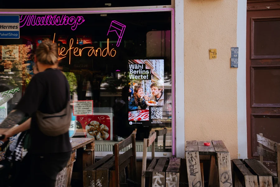 HYGH-Screen im Schaufenster mit dem Berlin-Kodex-Motiv Wähl Berlins Werte und QR-Code zur Abstimmung